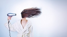 Frau mit Fön bläst sich die Haare ins Gesicht Elektroschrott wiederverwenden - zu wertvoll für die Tonne