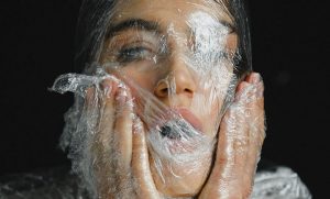 Plastiflut -Frau in Plastik gewickelt