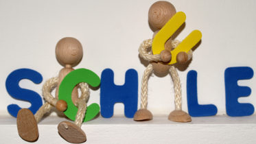 Schriftzug Schule aus Holz mit Holzmänchen